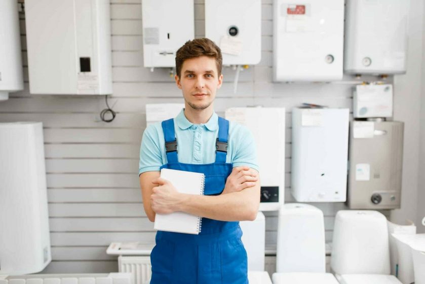 Plumber at showcase with boilers, plumbering store