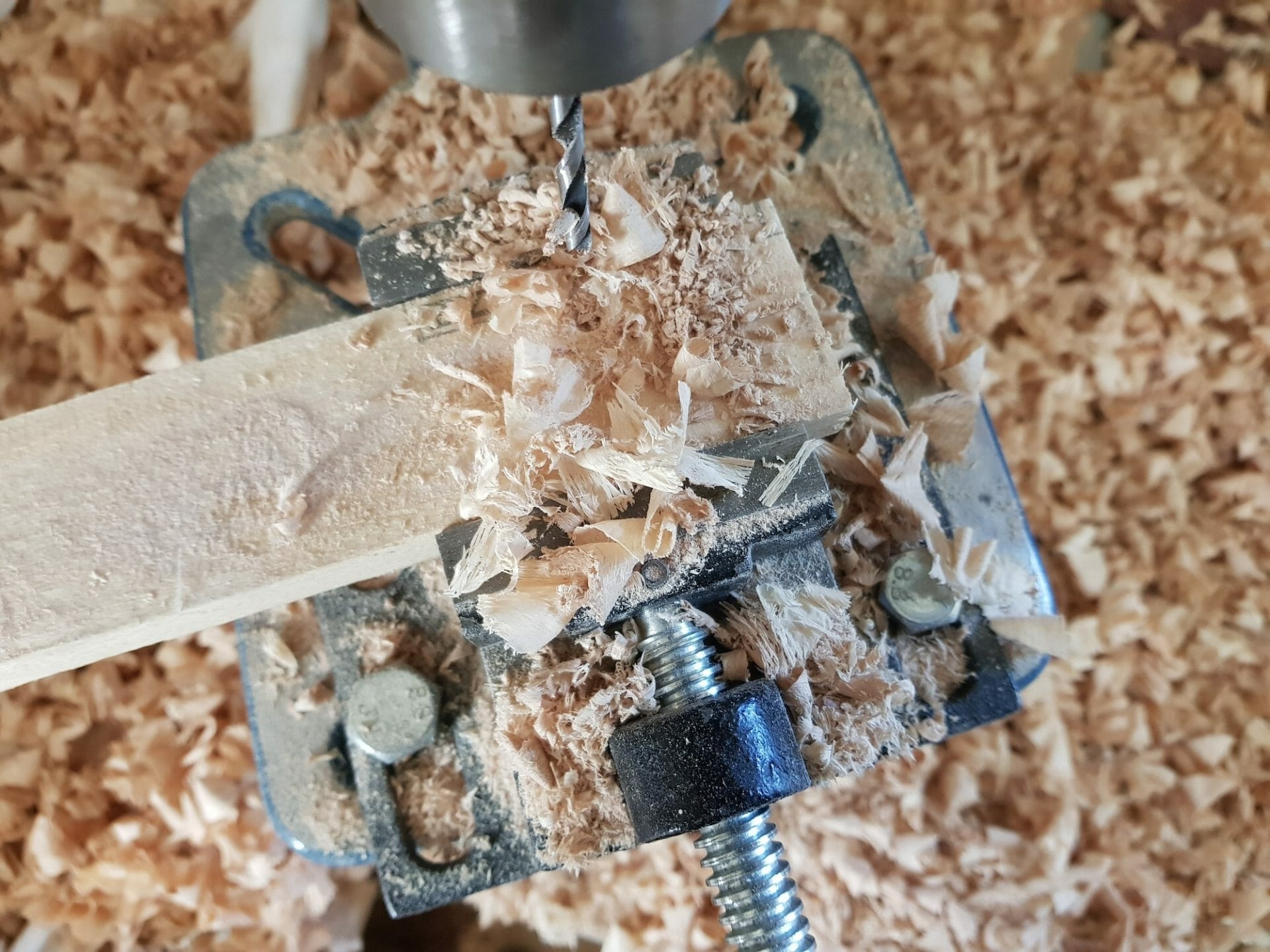 Close-Up Of Drill Press, Drill Bit, Drilling Through A Piece Of Wood.